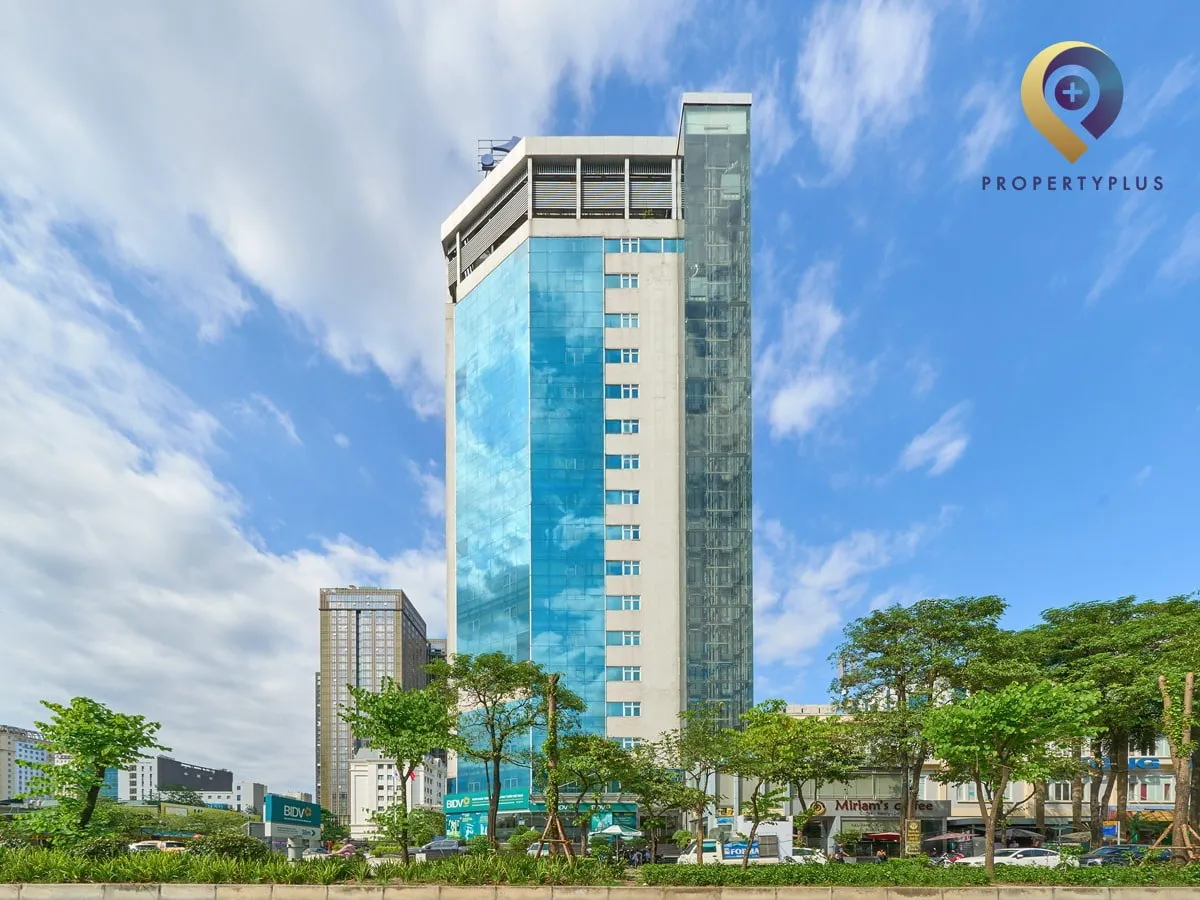 Góc nhìn khác của toà nhà Detech Tower với mặt kính xanh và cây xanh xung quanh